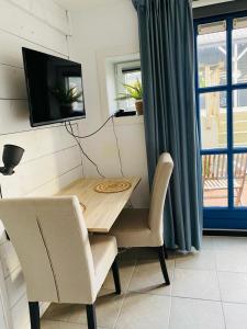 a dining room table with two chairs and a television at By Onzz in Kamperland