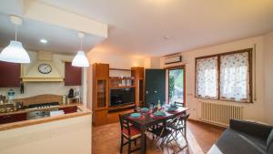 a kitchen and a dining room with a table at Casa Gioia a 5 minuti da San Marino in Montescudo