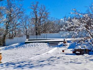 un patio cubierto de nieve con árboles y un edificio en Casa Rural Fuentecillas en Becedas
