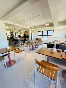 une cafétéria avec des tables et des chaises et des personnes en arrière-plan dans l'établissement Liiv Hub, à Natal