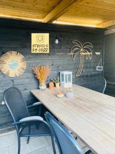 a wooden table and chairs in a patio at By Onzz in Kamperland