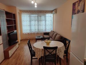 een woonkamer met een tafel en een bank bij Primorski Apartment in Varna