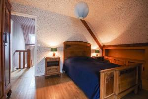 Schlafzimmer mit einem großen Bett mit blauer Decke in der Unterkunft 604 - Maison avec grand jardin calme et paisible proximité centre et plage d'Erquy in Erquy