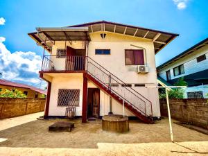 un edificio con una escalera en el lateral en Stunning 3-Bed House in Paramaribo Marie's place, en Paramaribo