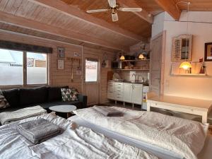 a bedroom with a bed and a couch and a kitchen at Piccobello Bed & Breakfast Valløby Køge in Valløby