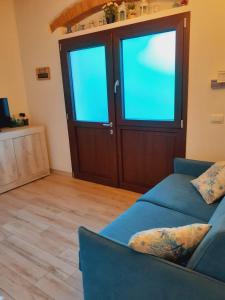 a living room with a blue couch and a door at CASA GAIA 3 in Portoferraio