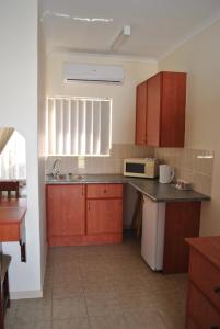 Una cocina con gabinetes de madera y encimera. en LeHiel Guesthouse, en Lichtenburg