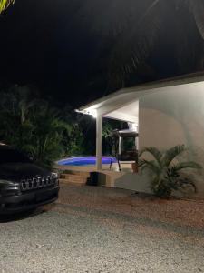 ein Auto, das nachts neben einem Pool parkt in der Unterkunft Exclusiva villa ecológica en las terrenas in Las Terrenas