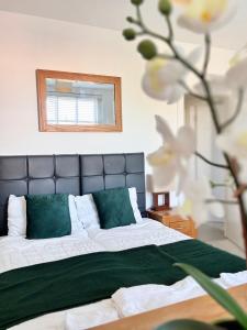een slaapkamer met een bed met groene en witte kussens bij Business Stays in Reading with FREE Parking in Reading