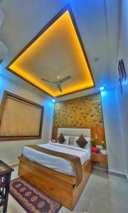 a bedroom with a large bed with a yellow ceiling at HOTEL TASTE OF INDIA in Agra
