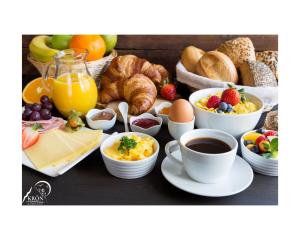 uma mesa de pequeno-almoço com alimentos de pequeno-almoço e café e croissants em Auberge Krön em Wakefield