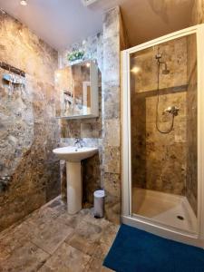 a bathroom with a sink and a shower at The Three Musketeers, Porthos in Eastbourne