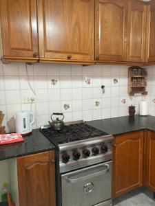 a kitchen with a stove and wooden cabinets at Casa Nelly in Playa Unión