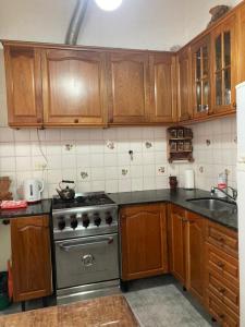 a kitchen with wooden cabinets and a stainless steel stove at Casa Nelly in Playa Unión