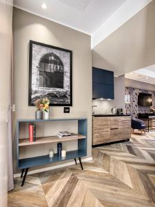 a living room with a blue shelf and a kitchen at Italianflat - Design rooms Verona in Verona