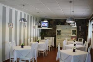 a dining room with white tables and white chairs at Casa Mariano in Revolta