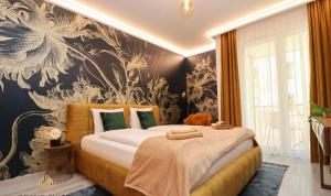 una camera da letto con un grande letto e carta da parati floreale di Grand Suites Central a Budapest