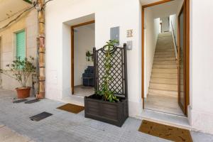 Un pasillo de una casa con una puerta y escaleras. en Bedda Luna Apartments, en San Vito lo Capo