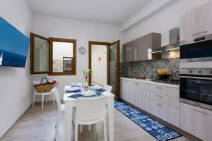 cocina con mesa blanca y sillas blancas en Bedda Luna Apartments, en San Vito lo Capo 26 fotos más