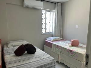 duas camas de solteiro em um quarto com janela em lindo apartamento de frente para à praia de pajuçara em Maceió