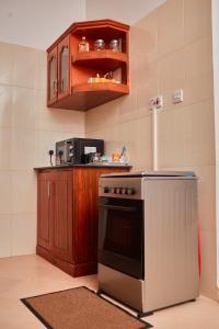 uma cozinha com um fogão e um micro-ondas em Mama's Home Stay em Dodoma