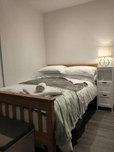 a bedroom with a bed and a night stand with a lamp at Cosy Garden Studio Room in Hove