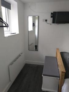 a room with a mirror and a bed and a table at Cosy Garden Studio Room in Hove