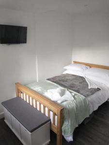 a bedroom with a bed with a flat screen tv at Cosy Garden Studio Room in Hove