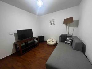a living room with a couch and a flat screen tv at Rinconcito de Paz en Xalapa in Xalapa