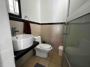 a bathroom with a white toilet and a sink at Rinconcito de Paz en Xalapa in Xalapa +34 photos