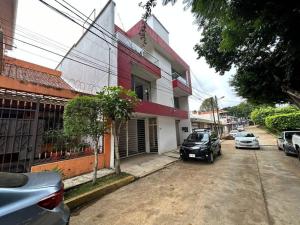 a street with cars parked in front of a building at Rinconcito de Paz en Xalapa in Xalapa