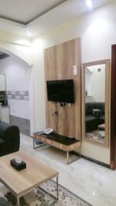 ein Wohnzimmer mit einem TV und einem Spiegel in der Unterkunft شقق روز شروره للشقق المخدومة in Sharorah