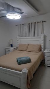 a bedroom with a bed with a blue pillow on it at Tu penthouse en torre real Vl monumental in Santiago de los Caballeros