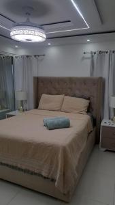 a bedroom with a large bed with a large headboard at Tu penthouse en torre real Vl monumental in Santiago de los Caballeros