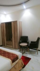 a room with a bed and a chair and a table at شقق روز شروره للشقق المخدومة in Sharurah