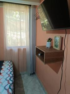 1 dormitorio con ventana y estante con planta en HospedajesMED, en Medellín