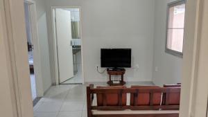a living room with a television on a wall at Residência Schneider RC in Vila Velha