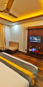 um quarto com uma cama e uma televisão na parede em HOTEL TASTE OF INDIA em Agra