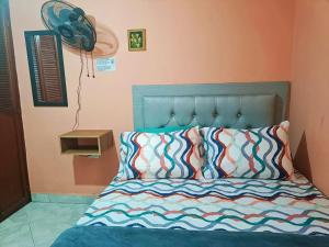 1 dormitorio con 1 cama y ventilador en la pared en HospedajesMED, en Medellín