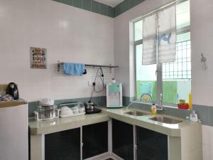 una cucina con bancone e lavandino e una finestra di Bidor Family Choice 3 Bedrooms WIFI a Bidur
