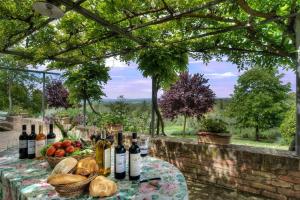 uma mesa com um monte de garrafas de vinho sobre ele em allegretti agriturismo em Castelnuovo Berardenga