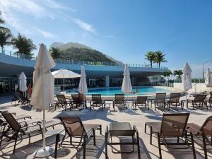 a group of chairs and umbrellas next to a swimming pool at Hotel Nacional SUITE COM BANHEIRA, vista do mar e Pedra da Gávea in Rio de Janeiro