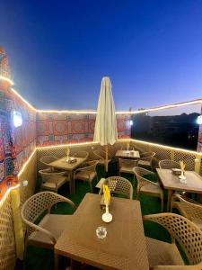 ein Restaurant mit Tischen, Stühlen und einem Sonnenschirm in der Unterkunft Secret of Horus in Kairo