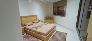 ein Schlafzimmer mit einem Bett und einem Stuhl darin in der Unterkunft Dar Assalam in Oualidia