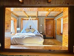 a bedroom with a bed in a room with wooden walls at Ch'i SoulStone Retreat in Sainj