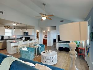 a living room with a blue couch and a kitchen at Beachy Keen in Surfside