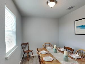 a dining room with a wooden table and chairs at Beachy Keen in Surfside