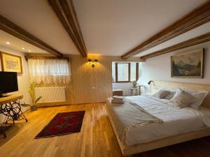 a bedroom with a large bed and a television at Casa IEUD in Sinaia