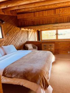 1 dormitorio con 1 cama en una habitación de madera en Taos Mountain Views- Cozy Home-Special Rates, en El Prado