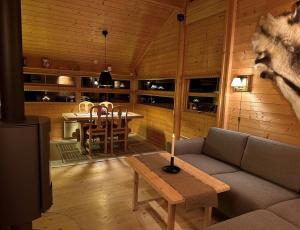 salon z kanapą i stołem w obiekcie Kinnkosen - cabin with panoramic view for 6 persons w mieście Holo